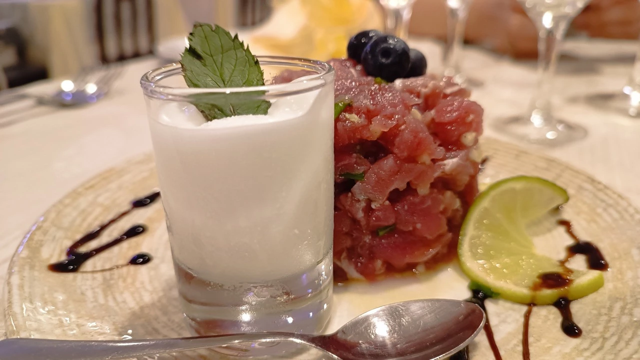 Piatto gourmet con tartare di tonno, sorbetto al limone e decorazione di lime e mirtilli, servito al ristorante Gian Maria