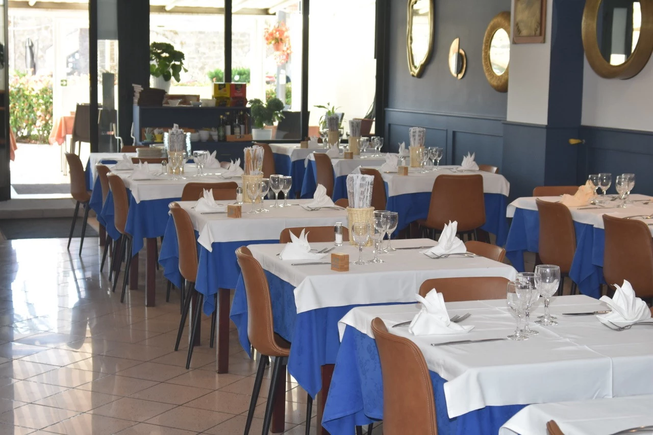 Sala interna del ristorante Gian Maria a Moneglia con tavoli apparecchiati in stile elegante blu e bianco
